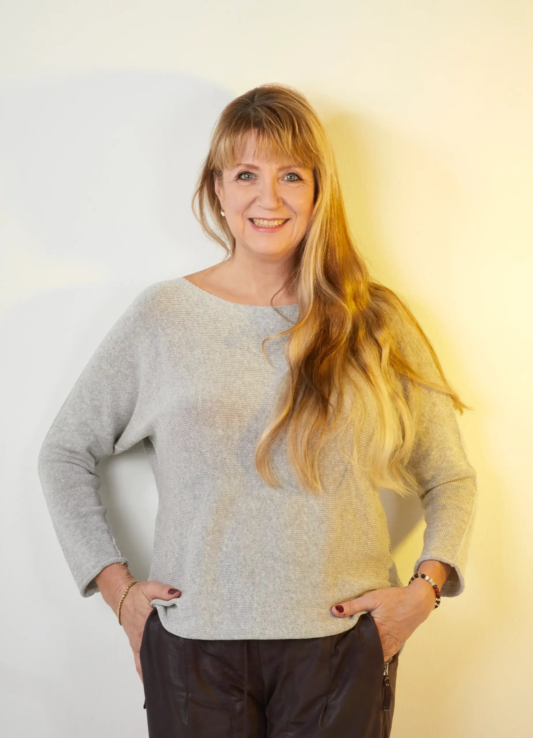 Portrait von Karolin Ewald im grauen Pullover mit angewinkelten Armen – Unterstützt auf dem Weg zur Selbstführung und Selbstachtung